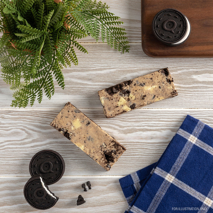 Two cookies and cream bars on a wooden surface