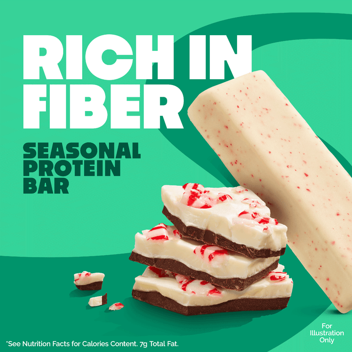 Promotional graphic for a seasonal protein bar, showing a large off-white bar with red speckles and stacked chocolate-coated pieces with red candy pieces, on a bright green background with large text reading 'RICH IN FIBER' and 'SEASONAL PROTEIN BAR'.