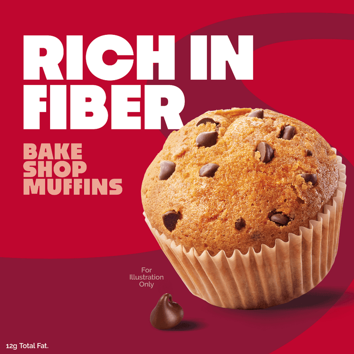 A promotional graphic for chocolate chip muffins on a red background. Large white text reads 'RICH IN FIBER' and smaller pink text reads 'BAKE SHOP MUFFINS.
