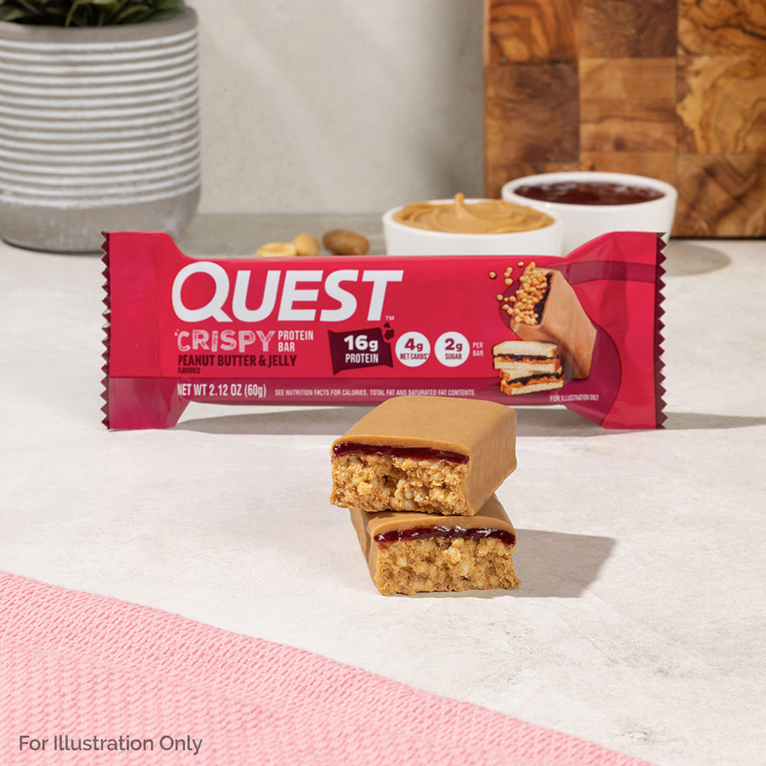 Quest Crispy protein bar with a bite taken out of it on a light surface.