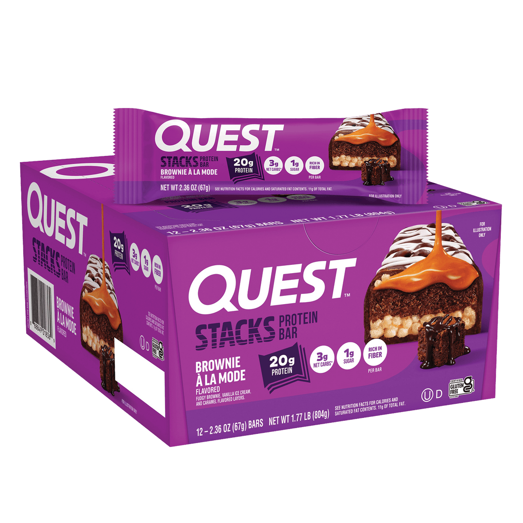 Box and wrapper of Quest Stacks Protein Bar in "Brownie à la Mode" flavor. The purple packaging highlights 20g protein with caramel drizzle imagery.