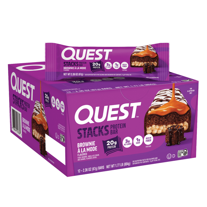 Box and wrapper of Quest Stacks Protein Bar in "Brownie à la Mode" flavor. The purple packaging highlights 20g protein with caramel drizzle imagery.